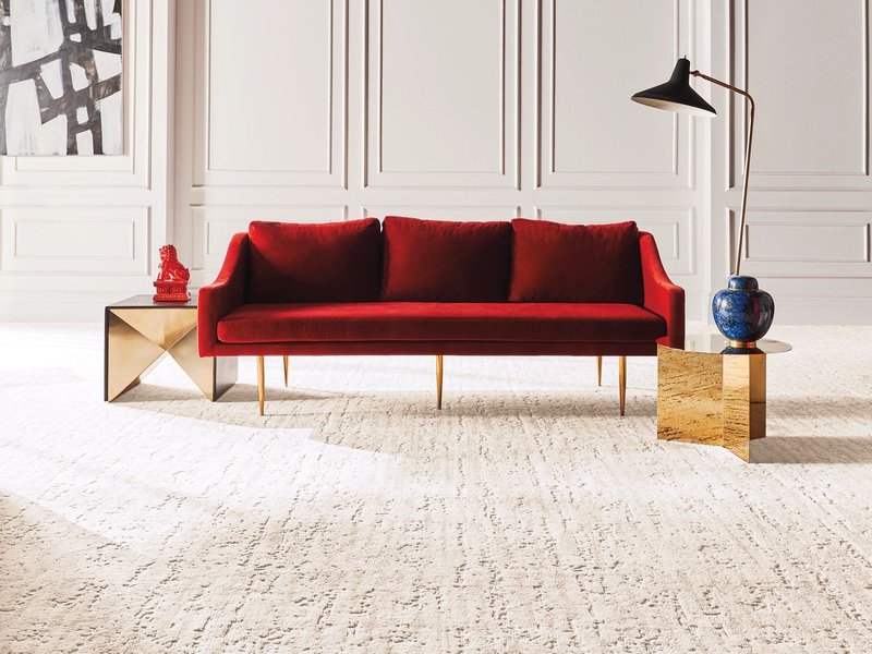 Bright living room with a red couch and beige carpet from New Horizon Carpets in the Hemet, CA area