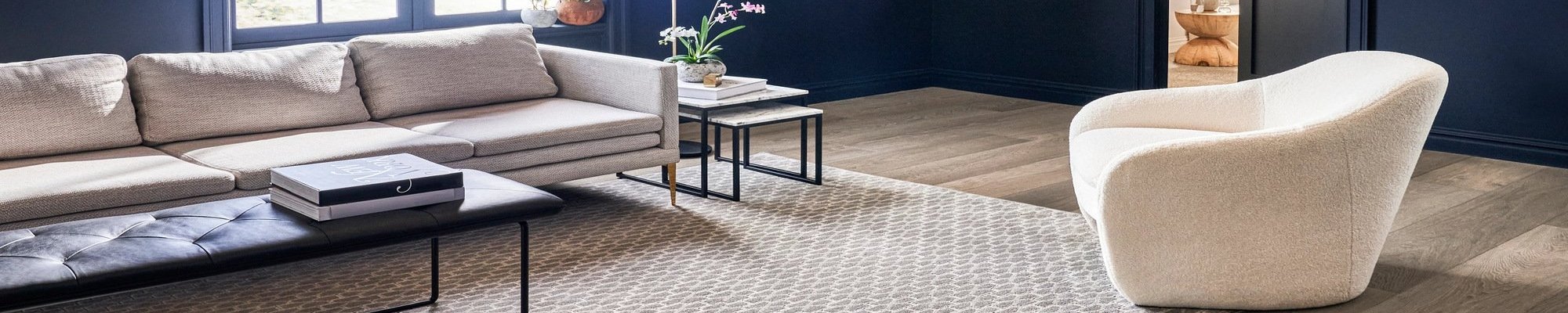 Couch and armchair on a rug in a living room with hardwood flooring from New Horizon Carpets in the Hemet, CA area